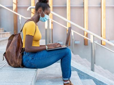 College student with laptop on steps
