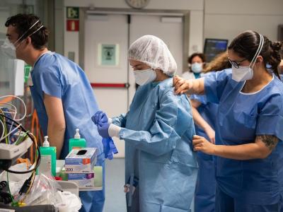 Group of COVID-19 healthcare workers putting PPE on