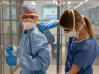 Healthcare workers donning COVID-19 protective equipment