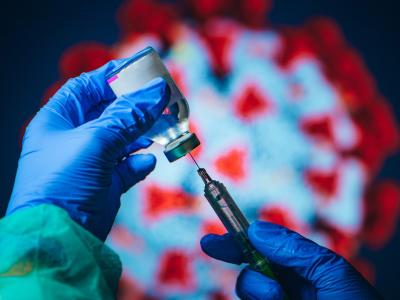 COVID vaccine with virus in background