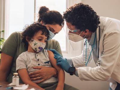 Doc prepping young boy for COVID vaccine
