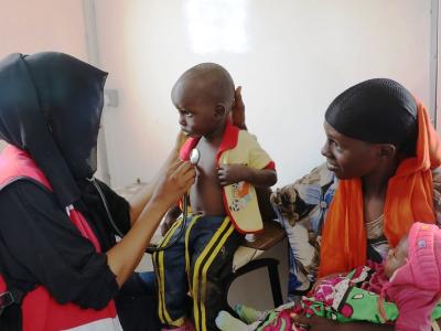 Doc checking small child with stethoscope in Africa