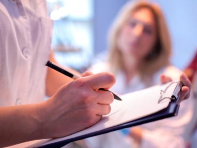 Doctor writing in patient's chart