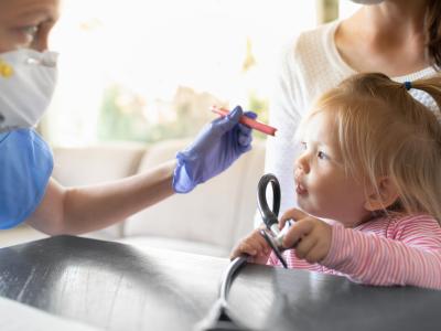 Doctor examining little girl