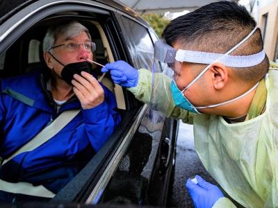 Woman in car gettnig nasal swab COVID test
