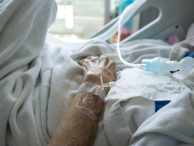 Elderly hand in hospital bed