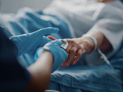 Older hospital patient with pulse oximeter on finger