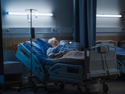 Elderly man in dark hospital room