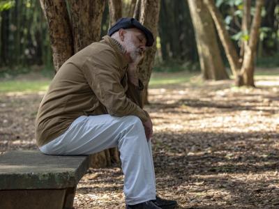 Tired older man on park bench