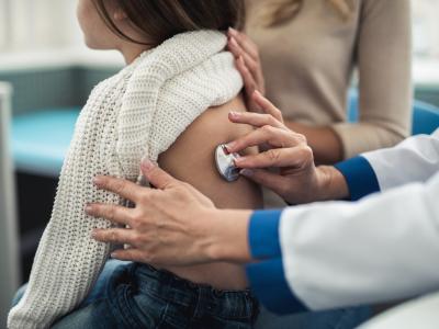 Doc with stethoscope on girl's back
