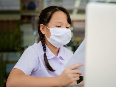 Girl wearing mask doing homework