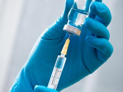 Gloved hands filling syringe