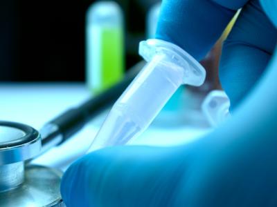 Gloved hand and research vial