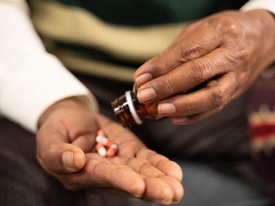 Hands of elderly man taking pills