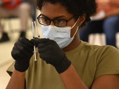 Healthcare worker holding 2 vaccine syringes
