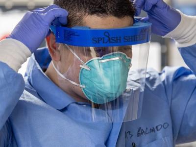 Health worker wearing respirator and face shield