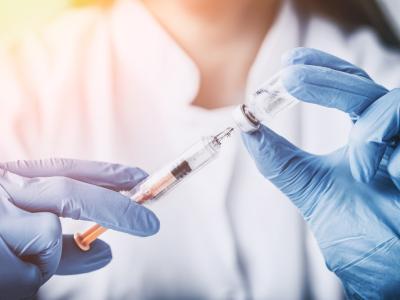 Health worker with syringe and vial