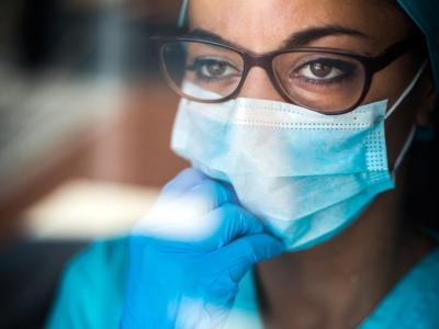 Healthcare worker wearing mask looking thoughtful