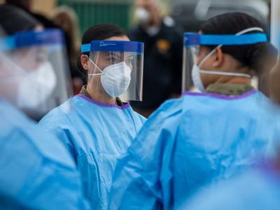 Health workers wearing N95s and face shields