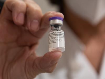 Health worker holding vial of COVID vaccine