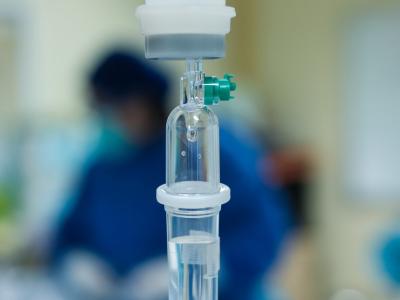 IV drip with blurred patient in background