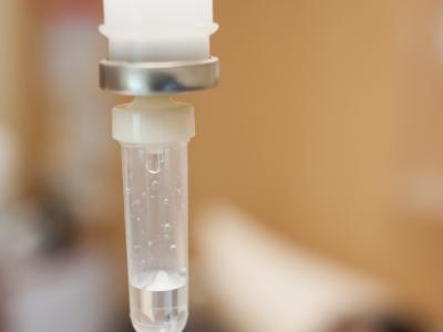 IV drip with blurred patient in background