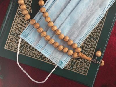 A Koran, mask, and prayer beads