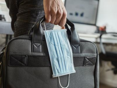 Man carrying briefcase and surgical mask