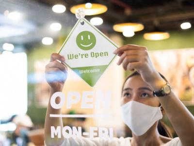 Masked business owner opening store
