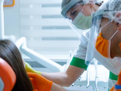 Masked dental workers with patient