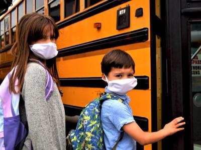 Masked kids boarding school bus
