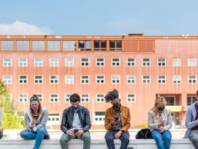 Masked students lined up on wall outside school