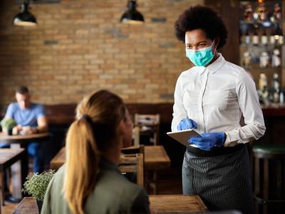 Masked waitress taking order