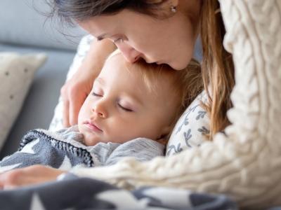 Mom kissing sick boy on forehead