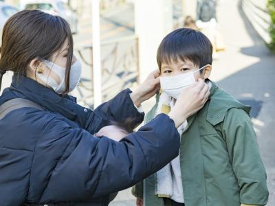 Mom putting mask on young son