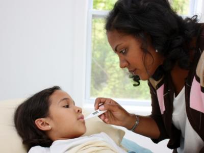 Mother taking temperature of child