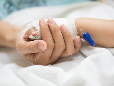 Mother holding child's hand in the hospital