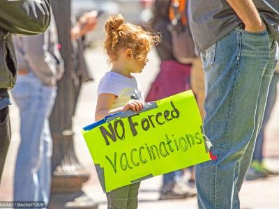 Girl with 'no forced vaccinations' sign