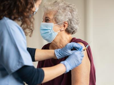 Nurse giving elderly woman vaccine