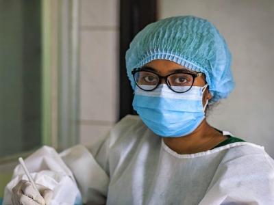 Nurse wearing mask, cap, and gloves