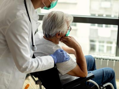Nursing home patient in wheelchair with caregiver