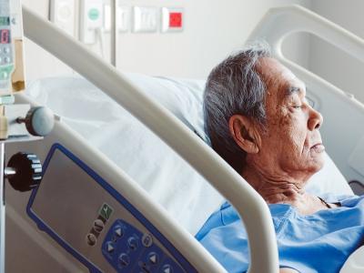 Older Asian man in hospital bed