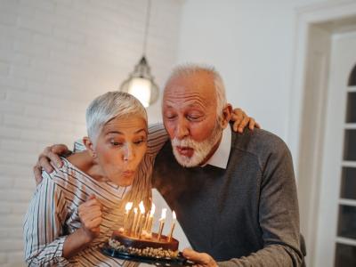 Older couple blowing out birthday candles
