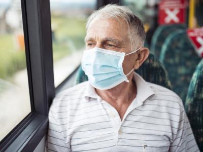 Older man wearing mask on bus