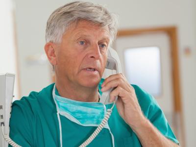 Older surgeon on phone