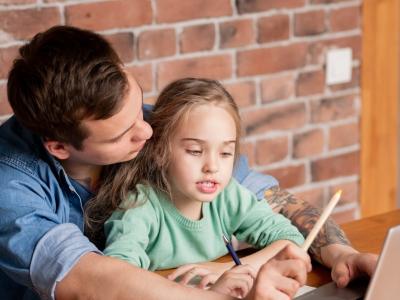 Daughter doing online learning with dad