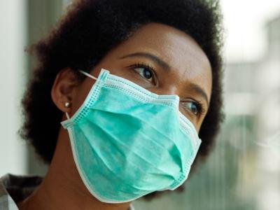 Pensive Black woman wearing mask