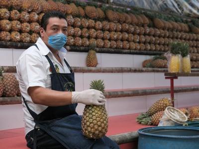 Pineapple seller wearing mask