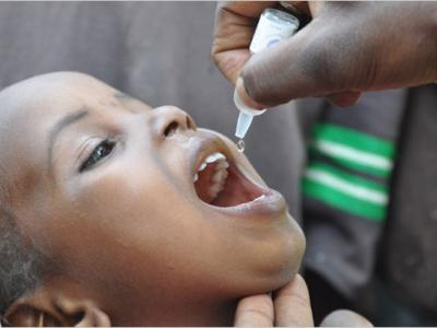 An African child is given oral polio vaccine.