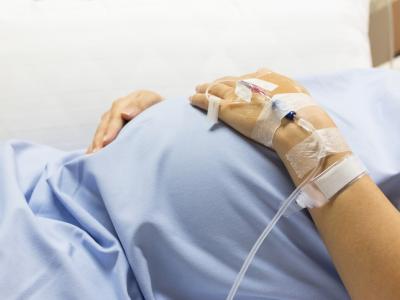 Pregnant belly of woman in hospital bed